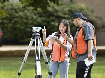Civil Engineering - photo of students outdoors with a transit on a tripod