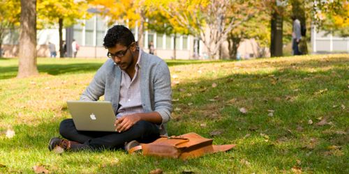 Alumni Header Image Student Sitting on Ground with Laptop 