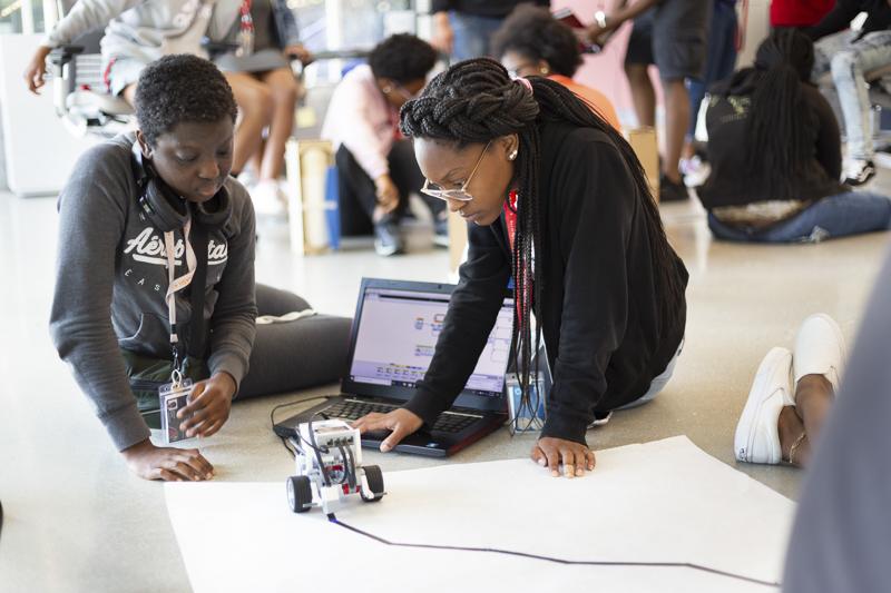 Students work to program a robot during a summer course
