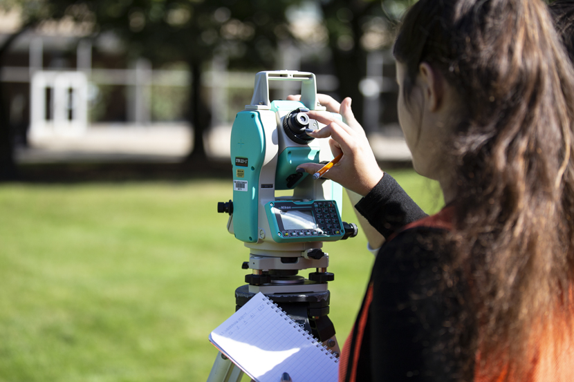 A student utilizes surveying equipment during a Civil Engineering class