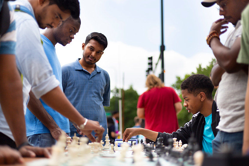 Students outside playing chess