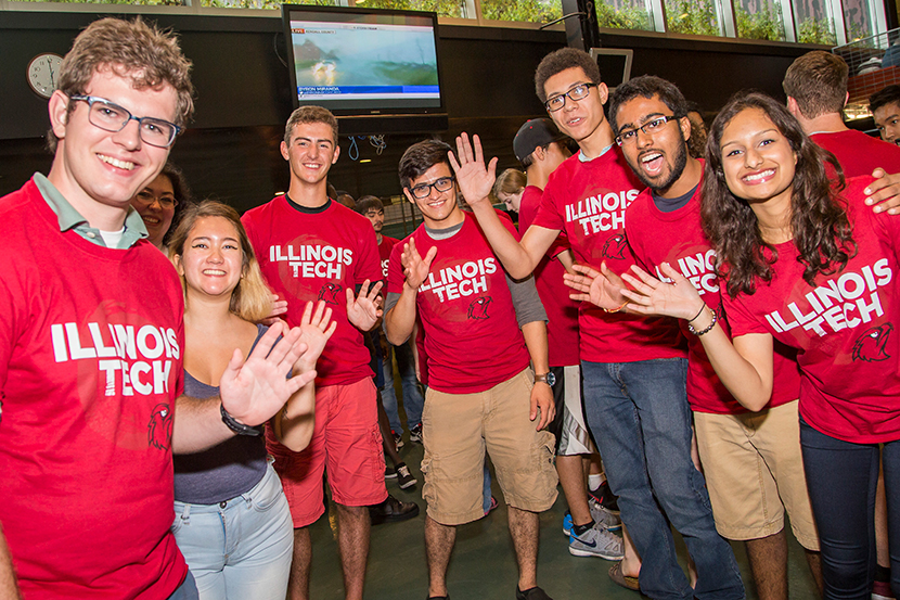 Multiple undergraduate students waving to the camera taking a group photo