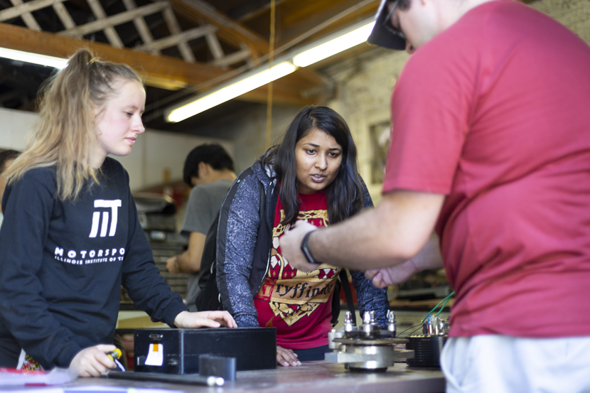 Students practice building car parts in the Armour Garage