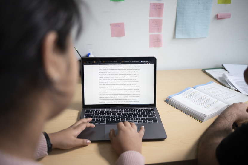 A student shows her paper to a staff member at the writing center