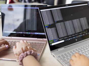 Two women work on code at Illinois Tech