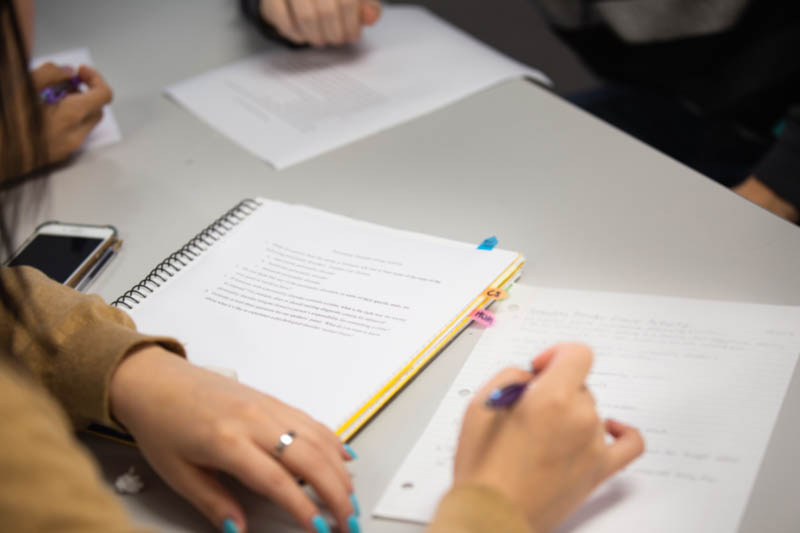 A student takes notes in a psychology class