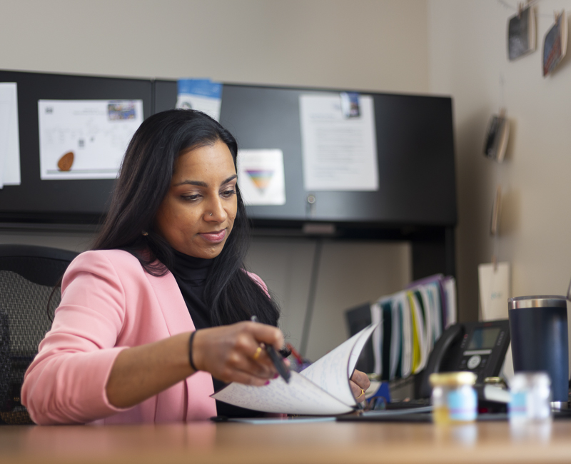 An alumna peruses paperwork in her office