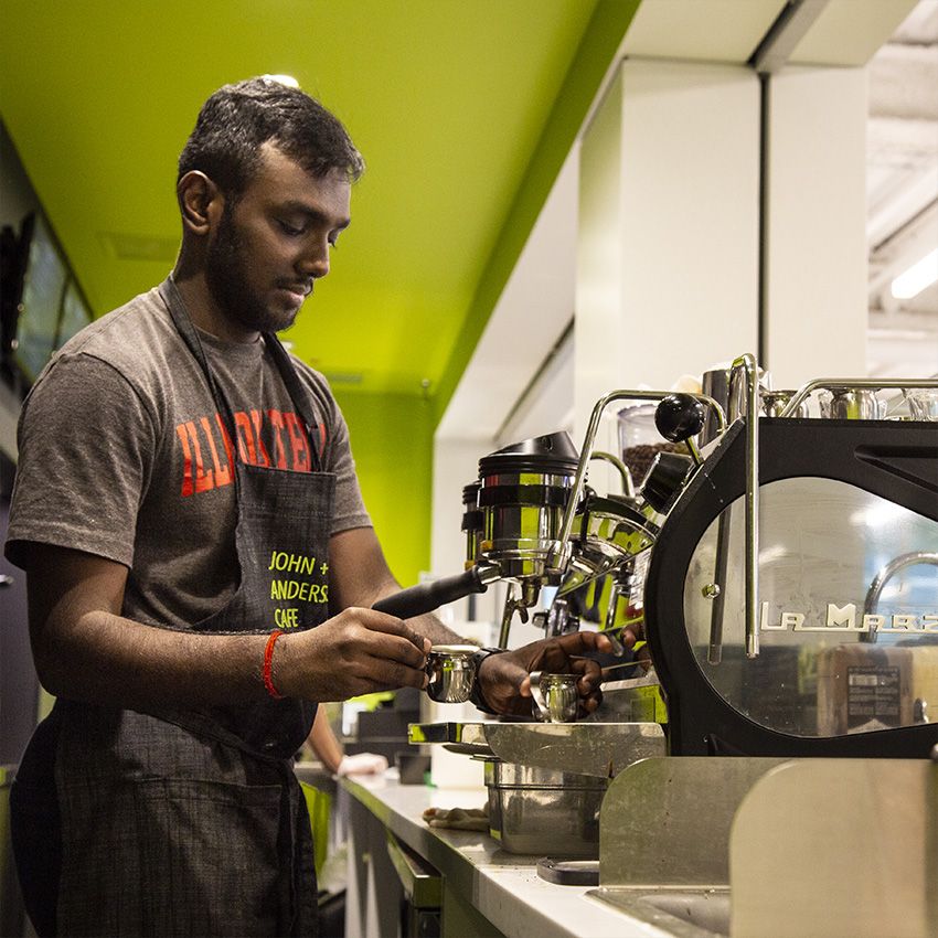 A student worker makes a latte in the cafe in Kaplan Institute
