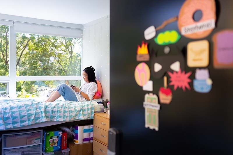 A student lounges in her room in Kacek Hall