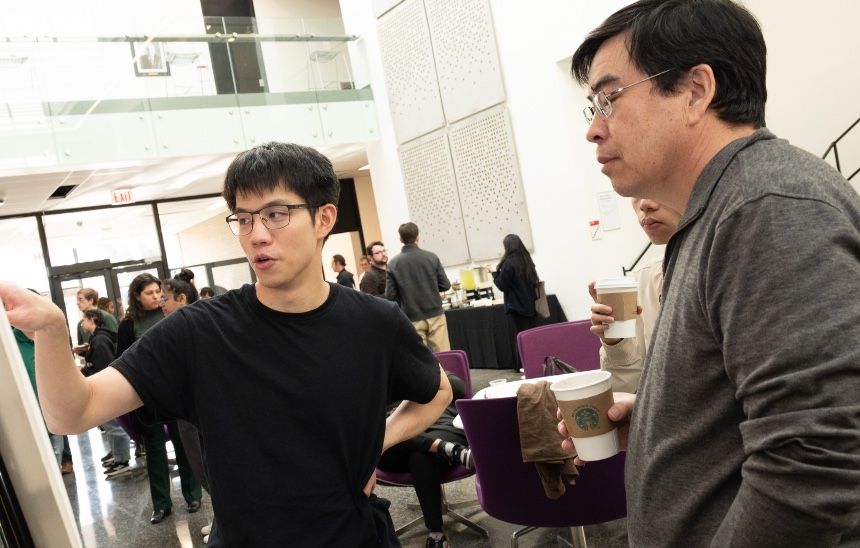 a mathematics students explains his research to faculty