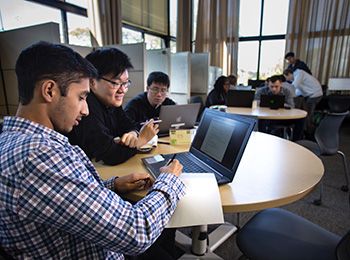 Students collaborating around tables