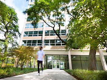 A student walks in front of Kacek Hall, a residence hall at Illinois Tech