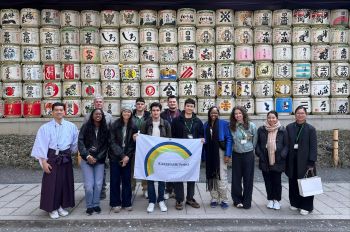 Architecture students pose in front of art piece in Japan
