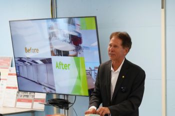 Daniel Tomal standing to the left of a screen 