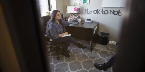 A therapist counsels a client in her office