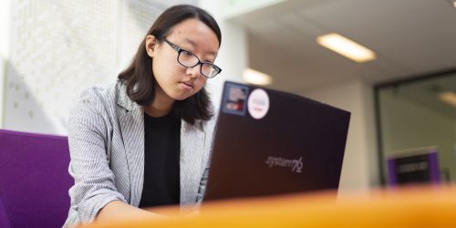 A data science student works on her laptop