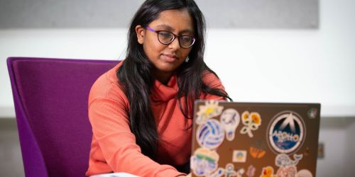 A female student discovers a creative solution to a real-world problem on her laptop