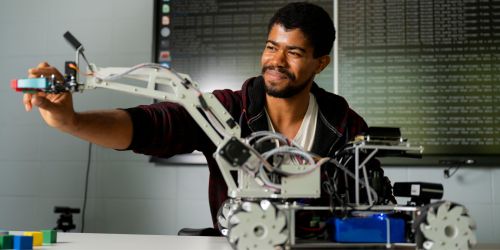 Illinois Tech male engineering student with model robot