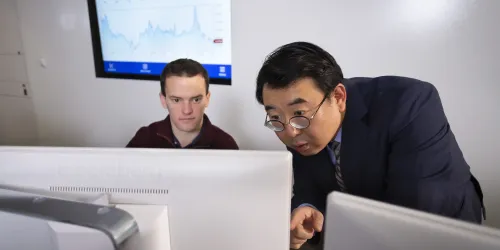 Image of professor and a student with a computer