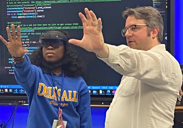 High school student tries VR goggles with Illinois Tech professor
