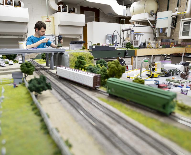 A student sets up a model in the model railroad club