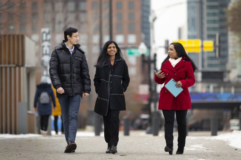 Two students and an alumna walk outside of Navy Pier where the three of them work