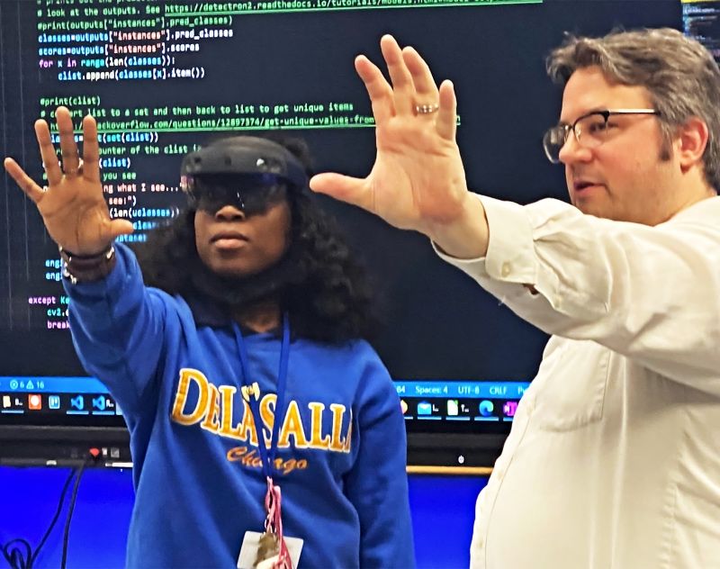 DeLaSalle student experiments with VR goggles under the guidance of an Illinois Tech professor