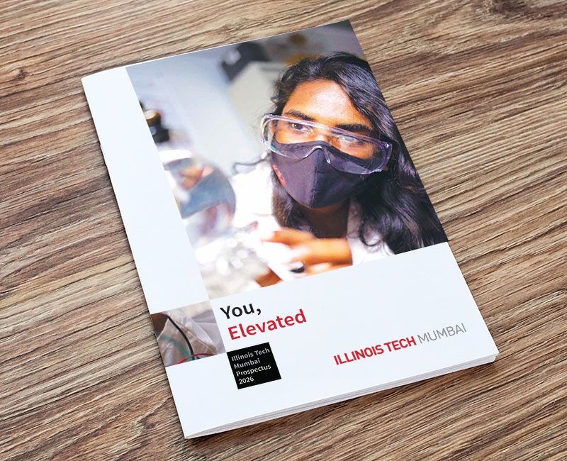 Prospectus for Illinois Tech Mumbai, presented as a printed booklet resting on a light-colored wooden surface.