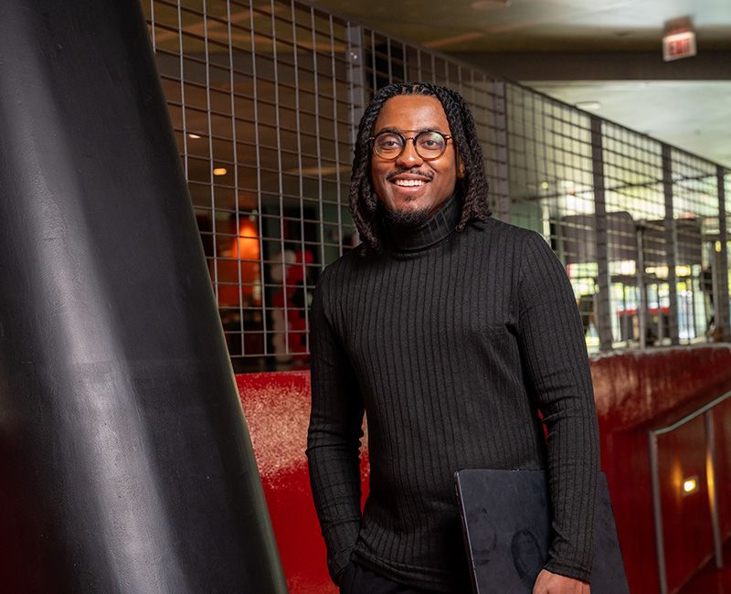 Cedric Nartey standing with a laptop